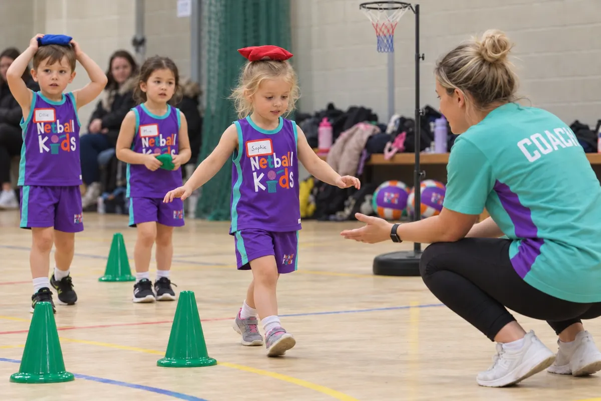 A coach kneeling down with young children